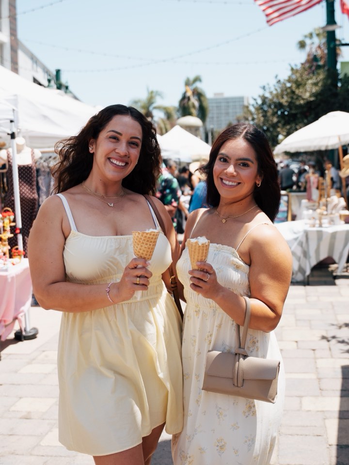 Two guests with drinks at a summer event