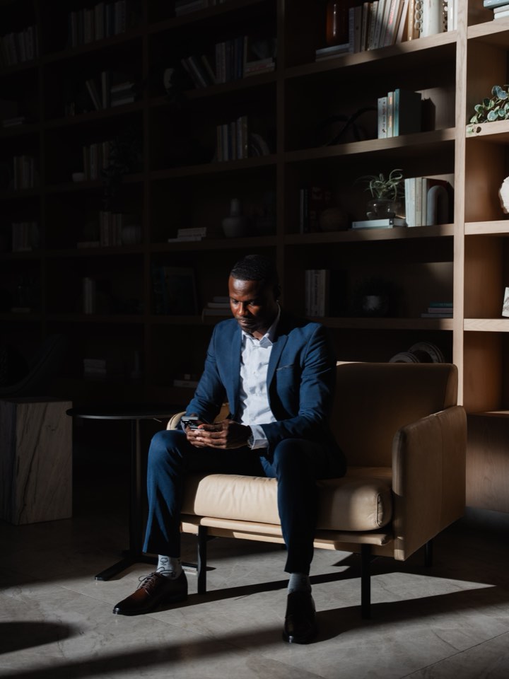 Founder seated in a library lounge, low evening light