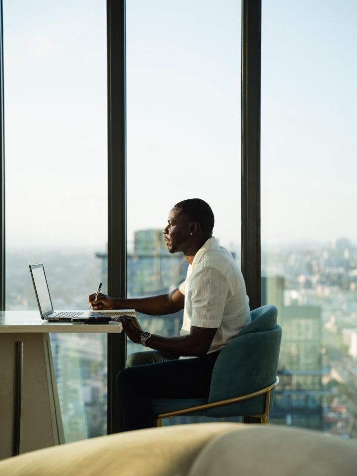 Working portrait at a laptop with a city view